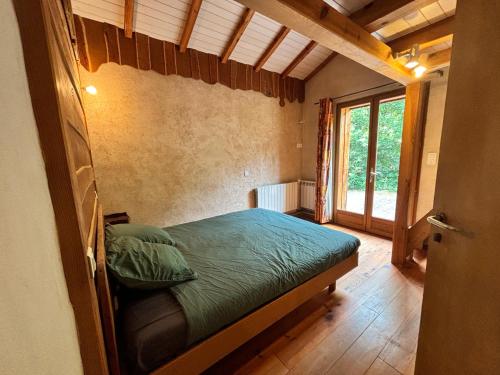 une chambre avec un lit dans une pièce avec une fenêtre dans l'établissement Maison agréable et écologique à sept kilomètres de l' océan, à Bias