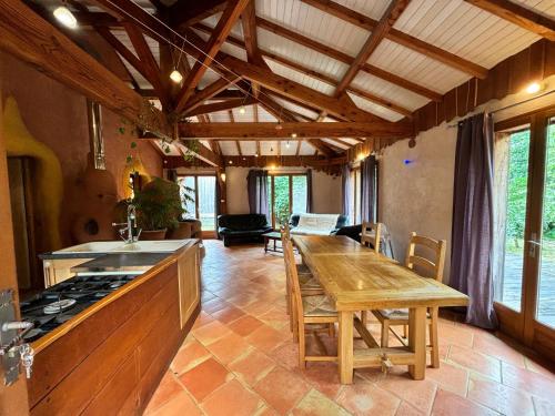 une grande cuisine avec une table en bois et une cuisinière dans l'établissement Maison agréable et écologique à sept kilomètres de l' océan, à Bias