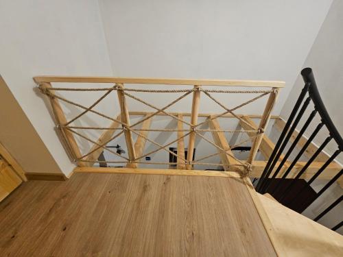 a staircase with a wooden rail and a wooden table at Nad Potokiem z Alpakami in Stronie Śląskie