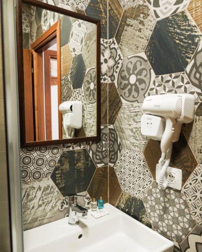 a bathroom with a sink and a mirror at 4 Rooms 1940 in Gjirokastër