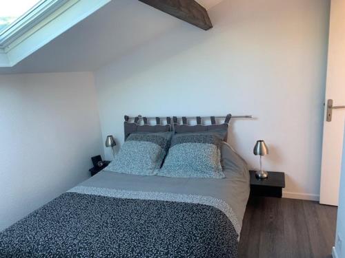 une chambre avec un grand lit avec des oreillers bleus dans l'établissement Les Terrasses du Port, à Hyères