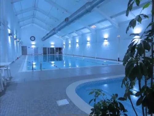 a large swimming pool with a large swimming pool at Secret Of Eden Seaside Escape in Filey