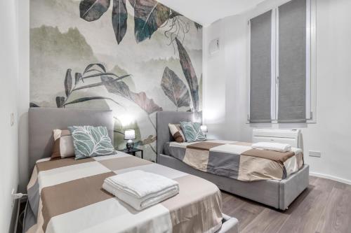 two beds in a room with a mural on the wall at Carbonara Palace 3 - Luxury Comfort under Medieval Towers in Bologna
