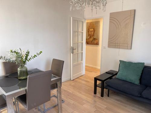 ヴィルヌーヴ・ラ・ガレンヌにあるTrès joli appartement mignon confortable à Paris Villeneuve-la-Garenneのテーブルとソファのあるリビングルーム
