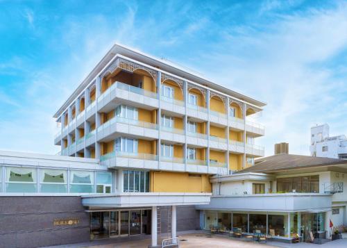 a large building with yellow and white at Hotel Kitano Plaza Rokkoso in Kobe