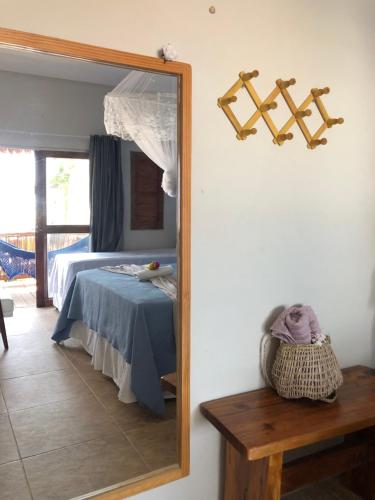 a mirror in a room with a bed and a table at Pousada Maré Cheia in Itarema