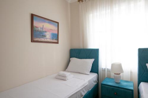 a bedroom with two beds and a picture on the wall at Montesan Luxury Apartment Beach Front in Sveti Stefan