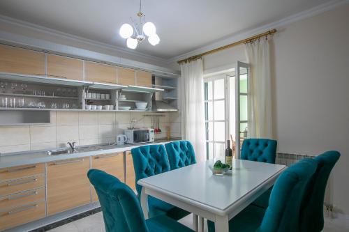 a kitchen with a table and blue chairs at Montesan Luxury Apartment Beach Front in Sveti Stefan