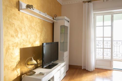 a living room with a television on a white cabinet at Montesan Luxury Apartment Beach Front in Sveti Stefan