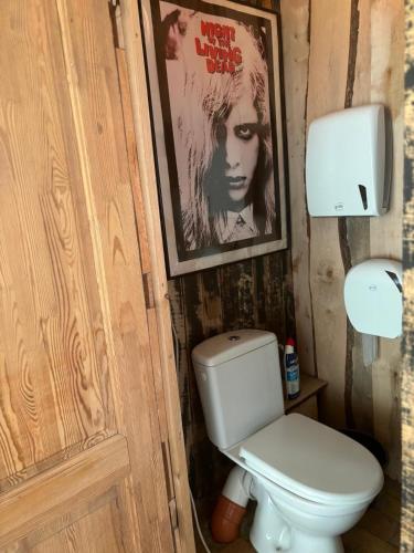 a bathroom with a toilet and a poster of a woman at Butterfly House in Pāvilosta