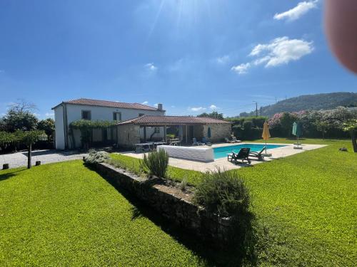 a house with a swimming pool in a yard at Casa dos castanheiros in Ponte de Lima