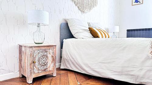 a bedroom with a bed with a lamp on a night stand at Suite Cinnabar - Check in h24 - Wifi in Oullins