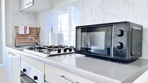 a microwave sitting on top of a kitchen counter at Suite Cinnabar - Check in h24 - Wifi in Oullins