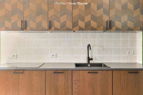 a kitchen with a sink and wooden cabinets at La Perpetua, Terre Marine in Riomaggiore
