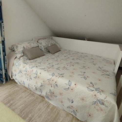 a small bed in a small bedroom with a bedspread with butterflies at Atico en Ajo Cantabria in Ajo