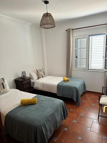 a bedroom with two beds and a pendant light at Casa Cueva de los Verdes in Punta Mujeres