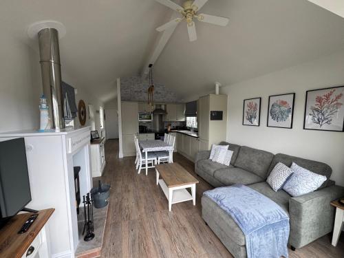 a living room with a couch and a table at Secret Of Eden Seaside Escape in Filey