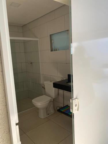 a bathroom with a toilet and a glass door at Casa Ubatuba in Ubatuba