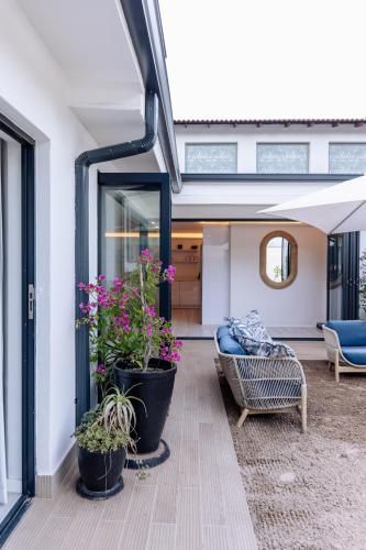 a patio with two potted plants and a chair at MINT Hotel 84 on Katherine in Johannesburg