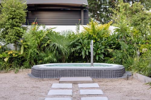 a stone fountain in the middle of a garden at MINT Hotel 84 on Katherine in Johannesburg