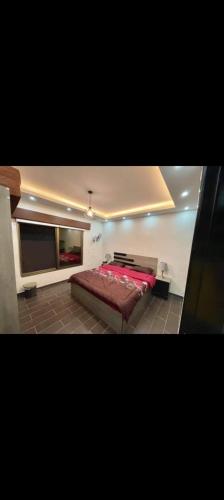 a bedroom with a red bed in a room at Naay Farm in Jerash