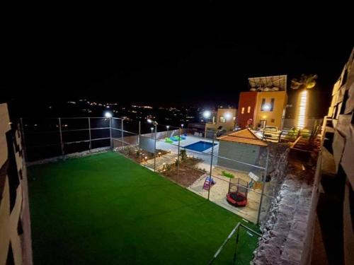 a night view of a swimming pool on a building at Naay Farm in Jerash