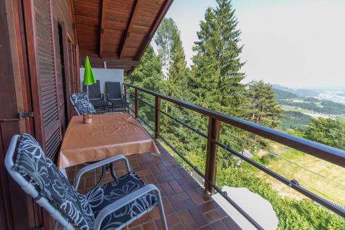 a porch with two chairs and a table on a balcony at Landhaus Karawankenblick in Himmelberg