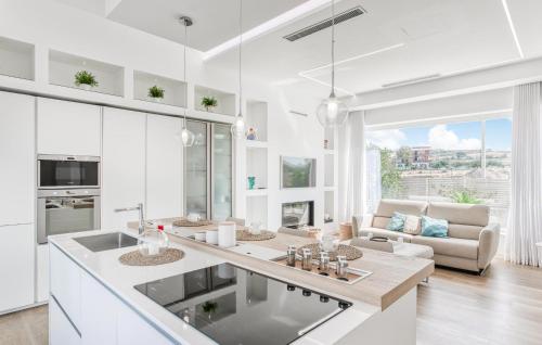 a kitchen with white cabinets and a living room at Stunning Home In Catenanuova in Centuripe