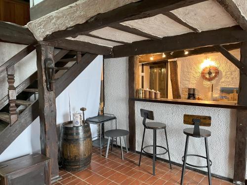 - un bar avec tabourets et un tonneau dans la pièce dans l'établissement Belle bergerie au cœur des montagnes, à Germs-sur-lʼOussouet