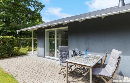 Un patio con una mesa y sillas de madera. en Beautiful Home In Ebeltoft With Wifi, en Ebeltoft