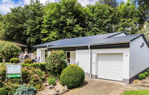 a white garage with a black roof at Holiday Home Gunderath With Fireplace I in Gunderath