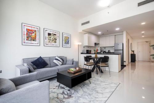 a living room with a couch and a table at Serenity Living - stunning 1BR, DAMAC Hills in Dubai