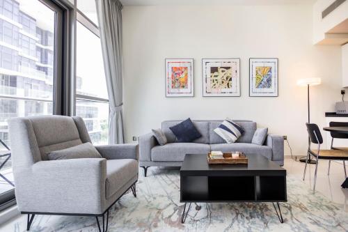 a living room with a couch and a table at Serenity Living - stunning 1BR, DAMAC Hills in Dubai