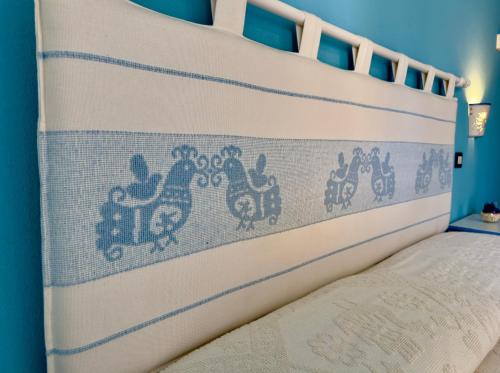 a bed with a bed frame with a bedspread with chickens on it at B&B Selvaggio Blu in Baunei