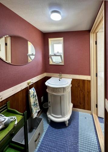 a bathroom with a sink and a mirror at まるごや 船でしか行けない離島の一棟貸し宿 in Hinase