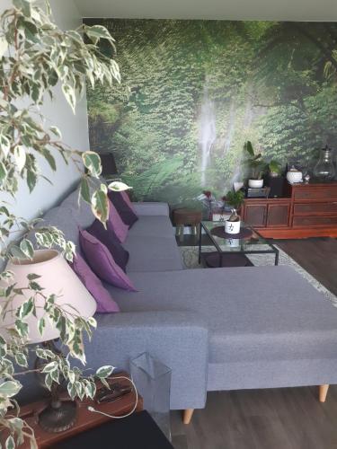 a living room with a bed with purple pillows at Appartement avec vue dégagée proche Paris in Boussy-Saint-Antoine