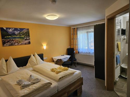 a hotel room with a large bed and a table at Alpengasthof Draxler in Forstau