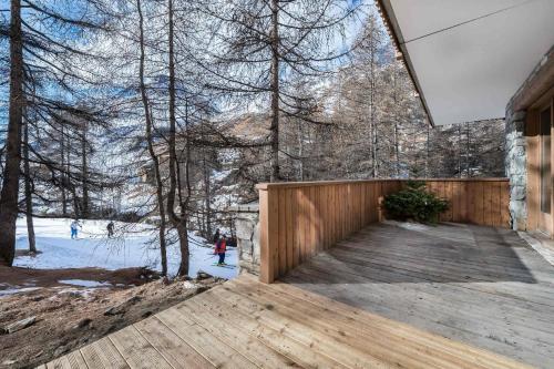 une terrasse en bois avec vue sur les bois dans l'établissement Luxueux duplex accès direct aux pistes avec piscine privée, à Val dʼIsère