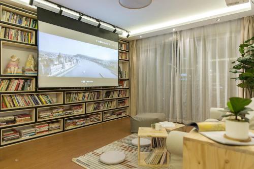 a living room with a large screen in a library at Book and Bed-People's Square in Shanghai