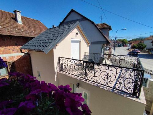 a balcony of a house with purple flowers at Apartman Djune in Arilje