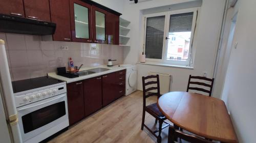 クラグイェヴァツにあるCentral Lake Apartmentのキッチン(木製テーブル付)、キッチン(テーブル、椅子付)