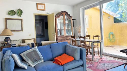 a living room with a blue couch and a table at Cottage da Fonte Seca in Ferreira do Zêzere