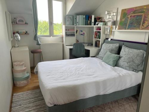 une chambre avec un lit et un bureau dans l'établissement Maison familiale entre Paris et Dysneland, à Montreuil