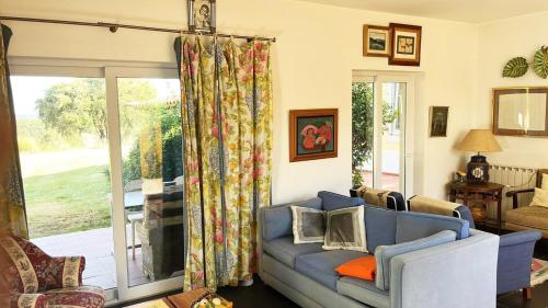 a living room with a couch and a sliding glass door at Cottage da Fonte Seca in Ferreira do Zêzere