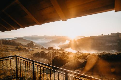 a view of a misty valley with the sun setting at Pousada Refúgio dos Vinhedos in Bento Gonçalves