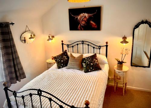 ein Schlafzimmer mit einem schwarzen Bett mit Kissen darauf in der Unterkunft 18th Century Cosy Cottage with Stunning views in Stratford in Stratford-upon-Avon