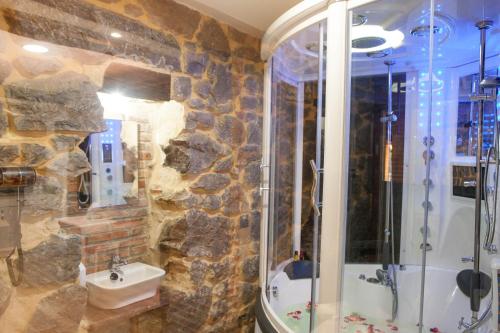 a stone bathroom with a shower and a sink at FUENTE OSCURA in Ramales de la Victoria