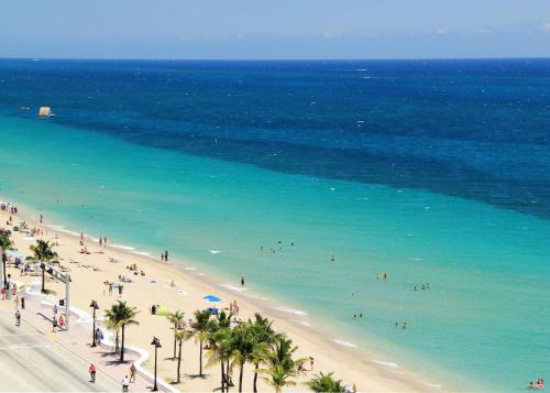 a group of people on a beach with the ocean at Wilton Manors Guesthouse in Fort Lauderdale