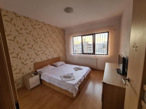 a small bedroom with a bed and a window at Lujerului residence in Bucharest