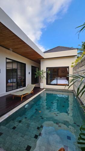 a swimming pool in front of a house at LM Home Mendira in Candidasa